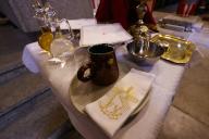 Catholic liturgical objects displayed over table at church. Chalice, communion wafers, wine and water. Eucharist celebration. Cluses. France