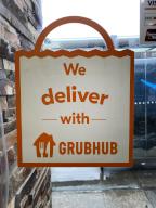 We Deliver with Grubhub sign in window of fast food restaurant, Queens, New York