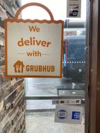 We Deliver with Grubhub sign in window of fast food restaurant, Queens, New York