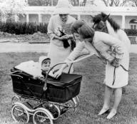 Washington, D.C.: April 12, 1962 Mrs. Jacqueline Kennedy introduces her son John to the Empress Farah of Iran as they tour the White House grounds. Behind her is the Kennedy pony, Macaroni.