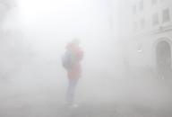 A pedestrian uses a cell phone while steam from a steam pipe surrounds the area on Wall Street in New York City on Friday, May 10, 2024. Photo by John Angelillo