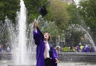 A graduating student wearing a cap and gown takes photos near the fountain in Washington Square Park on Wednesday, May 15, 2024 in New York City. A group of New York University student protesters walked out of their commencement at Yankee Stadium on Wednesday and demanded that university leaders divest from Israel. Photo by John Angelillo