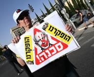 A woman holds a placard reading DANGER! with an photo of Israeli Prime Minister Benjamin Netanyahu at a protest calling for early elections and the immediate release of hostages held by Hamas in Gaza, outside the Knesset, the Parliament,on Monday, May 20, 2024. The International Criminal Court