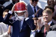 US President Joe Biden (L) puts on a Kansas City Chiefs helmet, beside Kansas City Chiefs owner Clark Hunt (R), during a ceremony welcoming the Kansas City Chiefs to the White House to celebrate their championship season and victory in Super Bowl LVIII, on the South Lawn of the White House in Washington, DC, USA, 31 May 2024
