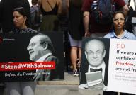 Supporters of author Salman Rushdie hold signs when they attend a New York literary event rally held in support of Salman Rushdie following last week