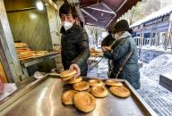 VCG111412155598 URUMQI, CHINA - NOVEMBER 28: Residents buy naan, a type of flatbread, at a store on November 28, 2022 in Urumqi, Xinjiang Uygur Autonomous Region of China. Urumqi is gradually restoring the normal order of work and life as the COVID-19 surge has been contained. (Photo by Liu Xin\/China News Service