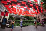 VCG111389989482 HONG KONG, CHINA - JULY 01: People take photos of China\'s national flags and the Hong Kong Special Administrative Region (HKSAR) flags hanging above a street on July 1, 2022 in Hong Kong, China. This year marks the 25th anniversary of Hong Kong\'s return to the motherland. (Photo by Zhang Wei\/China News Service