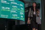 VCG111496458109 HONG KONG, CHINA - MAY 16: A pedestrian walks by a large electronic screen displaying the numbers for the Hang Seng Index on May 16, 2024 in Hong Kong, China. (Photo by Chen Yongnuo/China News Service/VCG 