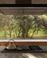 Picture window from kitchen hob to garden. Casa Terreno, n/a, Mexico. Architect: Fernanda Canales, 2018