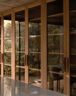 Built in timber cupboards with glass pane. Casa Terreno, n/a, Mexico. Architect: Fernanda Canales, 2018