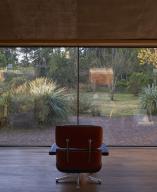 Chair and view through to landscaped garden. Casa Terreno, n/a, Mexico. Architect: Fernanda Canales, 2018