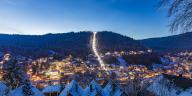 Germany, Baden-Wurttemberg, Bad Wildbad, Illuminated town in Black Forest range at winter dusk