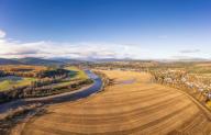 UK, Scotland, Aboyne, Aerial view of river Dee and vast field in autumn