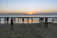 Indonesia, Bali, Denpasar, Tourists at Kuta beach photographing sunset