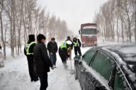 (121113) -- HOHHOT, Nov. 13, 2012 (Xinhua) -- Traffic policemen help move the trapped vehicle out of the snow-covered road in Naiman Banner of Tongliao City in north China