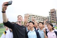 (240419) -- BEIJING, April 19, 2024 (Xinhua) -- Pole vaulter Chris Nilsen (front L) of the United States takes a selfie with local students during a pre-event school visit activity before the 2024 Wanda Diamond League Xiamen Meeting in Xiamen, southeast China\'s Fujian Province, April 18, 2024. (Xinhua\/Li Ming