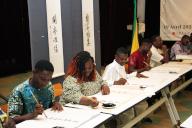 (240420) -- COTONOU, April 20, 2024 (Xinhua) -- Visitors learn Chinese calligraphy during a calligraphy exhibition at Chinese Cultural Center in Cotonou, Benin, on April 19, 2024. On the occasion of the United Nations Chinese Language Day, an exhibition of calligraphic works by Chinese artist Zhuang Hui, entitled "Calligraphy with a Pictorial Spirit" opened in Cotonou of Benin on Friday. (Photo by Seraphin Zounyekpe\/Xinhua