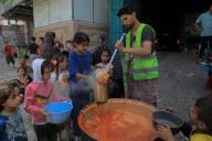 (240429) -- RAFAH, April 29, 2024 (Xinhua) -- Palestinian children receive food relief in the southern Gaza Strip city of Rafah, on April 28, 2024. (Photo by Rizek Abdeljawad\/Xinhua