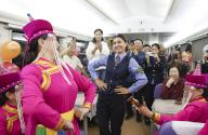 (240502) -- URUMQI, May 2, 2024 (Xinhua) -- Airkir Duliki and folk artists perform dance for passengers on a train from Kashgar to Chengdu in China, April 19, 2024. Airkir Duliki, the 27-year-old ethnic Tajik train conductor, was born and raised amidst the snow-capped mountains and grasslands in a village of Taxkorgan Tajik Autonomous County on the Pamir Plateau, where railways were not common for residents in the past. Airkir\'s initial experience with train travel occurred when she journeyed to Urumqi for university in Xinjiang. Accompanied by her father, she traversed over 300 kilometers of mountainous terrain from their village to reach the nearest Kashgar train station. Inspired by the first train journey, Airkir pursued a career in the railway sector after graduating from university in 2019. Since then, she has served as a train attendant on routes, linking Kashgar of northwest China\'s Xinjiang Uygur Autonomous Region and Chengdu of southwest China\'s Sichuan Province. Throughout her four
