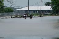 (240506) -- HOUSTON, May 6, 2024 (Xinhua) -- People carrying their dog wade through a waterlogged road in Channelview, east of Houston, Texas, the United States, May 5, 2024. At least one boy was killed and a woman injured on Sunday in floodwaters in Texas, where more than one third counties have issued disaster declarations during the past week due to heavy rainfalls that continue to pound the state. (Photo by Chen Chen\/Xinhua