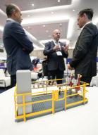 (240507) -- VANCOUVER, May 7, 2024 (Xinhua) -- People talk behind a model of a high-integrity pressure protection system at the Canada Gas Exhibition and Conference 2024 in Vancouver, British Columbia, Canada, on May 7, 2024. (Photo by Liang Sen\/Xinhua