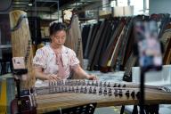 (240514) -- LANKAO, May 14, 2024 (Xinhua) -- A staff member sells guzheng, also known as Chinese zither, via livestreaming in Lankao County of Kaifeng City, central China