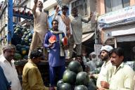 (240517) -- LAHORE, May 17, 2024 (Xinhua) -- Watermelon vendors chant to attract customers at a fruit market in Lahore, Pakistan on May 16, 2024. (Photo by Sajjad/Xinhua
