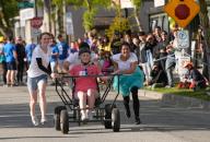 (240517) -- SURREY, May 17, 2024 (Xinhua) -- Participants compete during the annual Cloverdale Bed Race in Surrey, British Columbia, Canada, on May 16, 2024. Started in 1977, the traditional community event returned on Thursday, with participants teaming up to compete head-to-head on the street with their modified beds. (Photo by Liang Sen/Xinhua