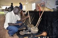 (240517) -- KAMPALA, May 17, 2024 (Xinhua) -- A man view exhibits at a stall during a community museum exhibition at Uganda National Cultural Centre in Kampala, Uganda, on May 16, 2024. This two-day event started here on Thursday to showcase the country