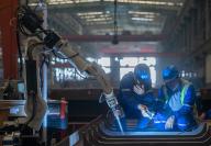 (240517) -- WUHAN, May 17, 2024 (Xinhua) -- Staff members check the work of a welding robot at a plant of Wuchang Shipbuilding Industry Group Co., Ltd. in Wuhan, central China
