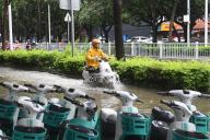 (240519) -- NANNING, May 19, 2024 (Xinhua) -- A citizen rides on a waterlogged street in Nanning, south China