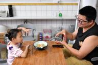 (240519) -- CHANGSHA, May 19, 2024 (Xinhua) -- Daughter Zhang Yuhan plays with her father Zhang Yongsheng during supper at home in Changsha, central China