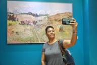 (240520) -- SUVA, May 20, 2024 (Xinhua) -- A visitor takes selfies at an exhibition of Chinese oil paintings showcasing the natural beauty and unique culture of China