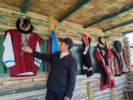 (240521) -- LHASA, May 21, 2024 (Xinhua) -- Tashi displays traditional costumes of Lhoba ethnic group in his cabin in Medog County, southwest China