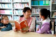 (240524) -- MINQIN, May 24, 2024 (Xinhua) -- Pei Aimin shares her reading experience with local primary school students, who are also left-behind children, in Minqin County, north China