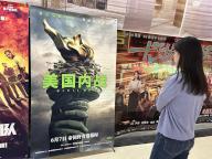 (240524) -- BEIJING, May 24, 2024 (Xinhua) -- A person views a poster of the U.S. movie "Civil War" in Beijing, capital of China, May 24, 2024. TO GO WITH "U.S. movie "Civil War" to hit screens on Chinese mainland" (Xinhua/Shen Anni