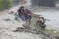 (240527) -- KHULNA, May 27, 2024 (Xinhua) -- Locals repair an embankment damaged during cyclone Remal in Khulna, Bangladesh on May 27, 2024. At least seven people died in Bangladesh due to the devastations of cyclone Remal, which lashed parts of the South Asian country with heavy rain and strong wind on Sunday night. (Xinhua