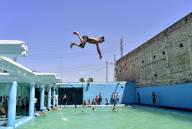 (240528) -- PESHAWAR, May 28, 2024 (Xinhua) -- A boy jumps into a swimming pool to beat the heat during a hot summer day in Peshawar, Pakistan, May 28, 2024. (Photo by Saeed Ahmad/Xinhua