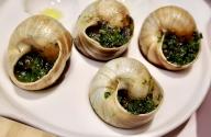 (240531) -- BEIJING, May 31, 2024 (Xinhua) -- This photo taken on May 20, 2024 shows a French classic dish parsley-buttered snails at the diner "La Maison Lyonnaise" in Beijing, capital of China. TO GO WITH "Letter from China: Savoring authentic French delicacies in Beijing" (Xinhua/Wang Yue