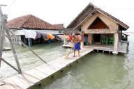 (240603) -- DEMAK, June 3, 2024 (Xinhua) -- A man cleans his living area surrounded by water in Timbulsloko village in Demak, Central Java, Indonesia, June 3, 2024. Rising sea levels and subsidence of the land surface have resulted in some villages being surrounded by sea water. (Xinhua/Bram Selo
