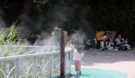 Already summer A kid plays under the cooling fog system at a lake park in Changwon, South Gyeongsang Province, on June 1, 2024, when the day\'s highest temperature reached 26 C. (Yonhap)\/2024-06-01 15:13:32\/ < 1980-2024 YONHAPNEWS AGENCY.